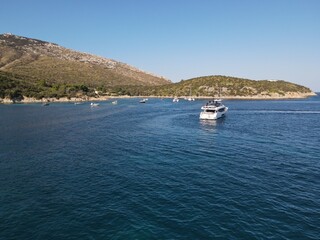 Aerial view of Cala Moresca and Figarolo Island in Golfo Aranci, north Sardinia. Birds eye from above of yacht, boats, crystalline and turquoise water. Tavolara Island in the background, Sardegna.