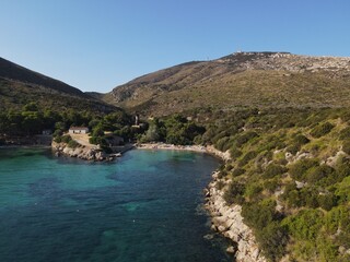 Aerial view of Cala Moresca and Figarolo Island in Golfo Aranci, north Sardinia. Birds eye from above of yacht, boats, crystalline and turquoise water. Tavolara Island in the background, Sardegna.