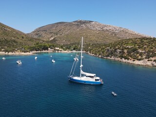 Aerial view of Cala Moresca and Figarolo Island in Golfo Aranci, north Sardinia. Birds eye from above of yacht, boats, crystalline and turquoise water. Tavolara Island in the background, Sardegna.