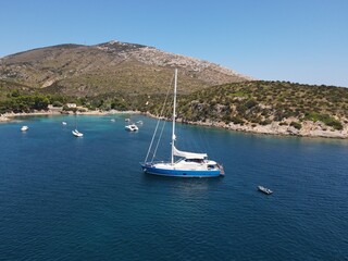 Aerial view of Cala Moresca and Figarolo Island in Golfo Aranci, north Sardinia. Birds eye from above of yacht, boats, crystalline and turquoise water. Tavolara Island in the background, Sardegna.