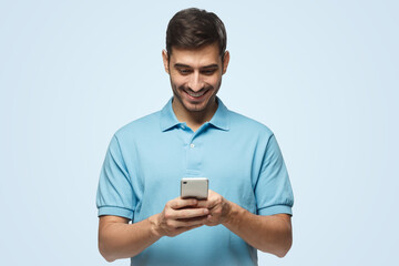 Man looking at screen of his phone with smile, browsing web pages, chatting with friend