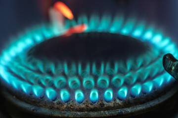 Blue flame of burning gas fire on a dark background. Gas as an energy resource