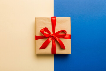 holiday brown paper present tied red ribbon bow top view with copy space. Flat lay holiday background. Birthday or christmas present. Christmas gift box concept with copy space