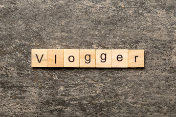 vlogger word written on wood block. vlogger text on table, concept