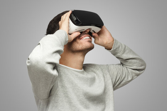 Fototapeta Caucasian male wearing virtual reality headset having great fun while gaming