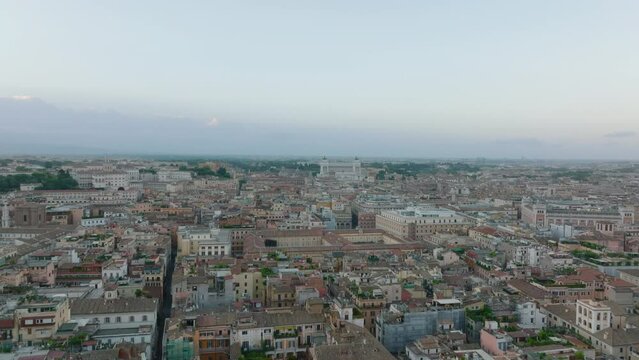 High angle view of old houses in historic city centre at twilight. Tilt down on Piazza Colonna with Colonna di Marco Aurelio. Rome, Italy