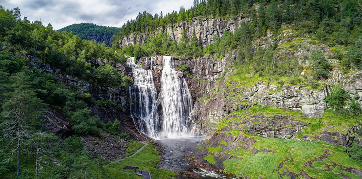 Skjervsfossen waterfall, on the road between Granvin and Voss, Vestland, Norway. Impressive beautiful win falls plunging 150 metres in a narrow canyon