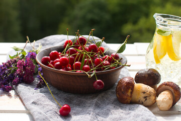 porcini mushrooms and cherry berries in a basket. Harvesting