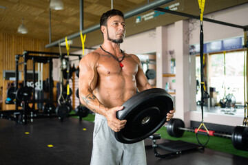 Fototapeta na wymiar Man exercising with discs in a gym