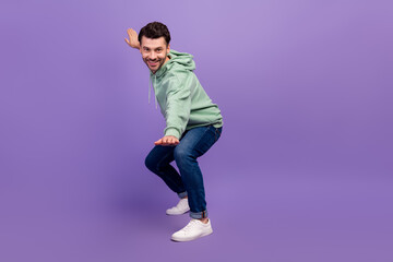 Fototapeta na wymiar Full length photo of young hipster man wear nice outfit khaki hoodie denim positive calm smiling posing looking you isolated on bright violet color background