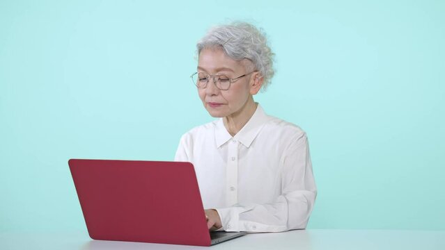 ノートパソコンを使うシニア女性
