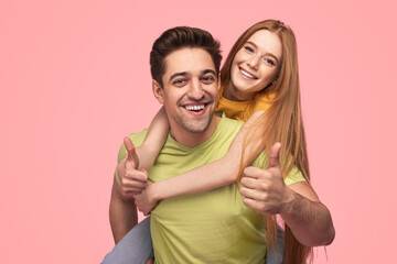 Content guy giving piggyback ride to girlfriend while showing OK gesture