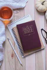 Holy bible and autumn cozy top view on wooden background. Bible study autumn concept