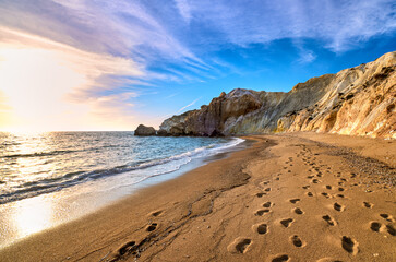 Low sun over beach, cliffs and hills and deep azure sea. Agios Ioannis