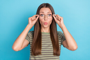 Photo of good mood impressed girl with straight hairdo dressed striped t-shirt fingers touch glasses isolated on blue color background