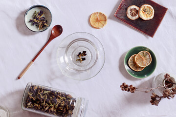 Overhead view of dried butterfly pea flowers or Clitoria ternatea and dried lemon slices for making a healthy and healing herbal tea