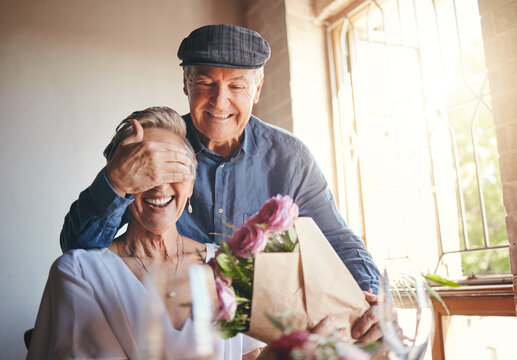 Love, flowers and surprise gift with elderly couple in celebration of a birthday or anniversary, happy and romantic. Family, marriage and senior man and woman celebrating their relationship together - Powered by Adobe
