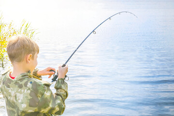 Boy fishing. The child pulls the bait at the time of the bite of the fish. Fish catch. Active outdoor recreation.