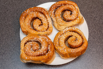 Many tasty cinnabons buns (kanelbullar) with sugar filling, swedish specialty
