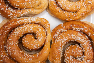 Many tasty cinnabons buns (kanelbullar) with sugar filling, swedish specialty