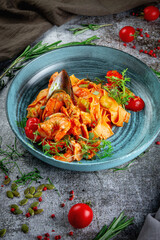 Tagliatelle with seafood, shrimp and oysters in delicate tomato sauce