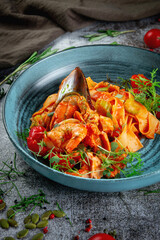 Tagliatelle with seafood, shrimp and oysters in delicate tomato sauce