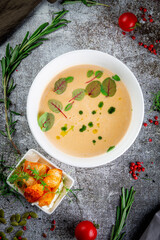 Pumpkin carrot puree soup on a gray stone table