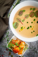Pumpkin carrot puree soup on a gray stone table