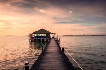 Bar and wooden bridge in the sea at the sunset