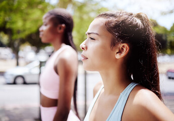 Fitness woman, focus and friends for workout, exercise and running marathon with mindset in urban city outdoor. Thinking athlete, runner and young sports person ready start healthy cardio challenge