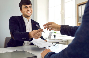 Two happy people meet in the office, make a business deal and sign a contract agreement. Friendly...