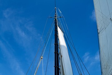 mast of a ship with a white sail