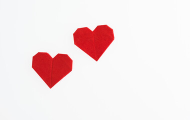 Red origami hearts on white background