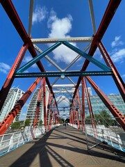 Looking up at a steel  bridge painted red and blue. Landmark bridge in Salford Quays England.  