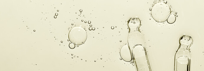 Two pipettes and a skin serum texture. Liquid body care product. Closeup.
