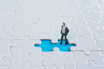 Businessman figurine on jigsaw piece