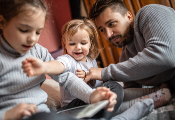Father playing and joking with his daughters in bedroom
Cozy time wih father
Father daughter time