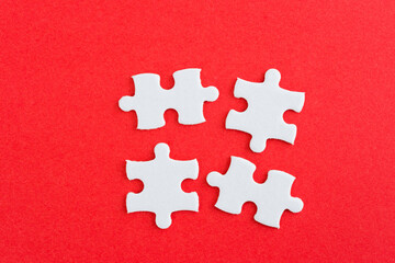 Four puzzle pieces on red background
