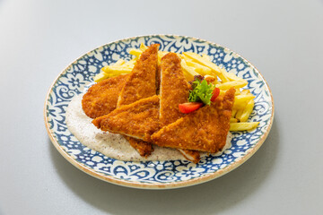 Tender pan fried chicken breasts served with french fries