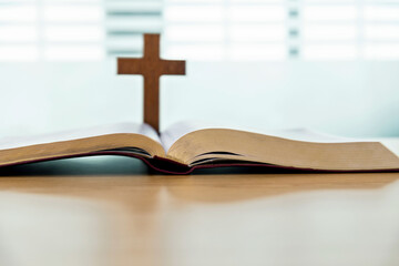 Wooden cross and bible book on the table