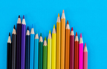 A row of color pencils on blue background