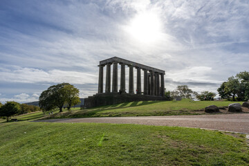 Fototapeta na wymiar Calton hill with neoclassical monuments and striking view of the urban skyline