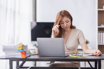 Obraz premium Asian businesswoman are stressed while working on laptop, Tired asian businesswoman with headache at office, feeling sick at work copy space in workplace an home office.