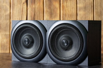 Two wooden audio speakers with a metal grille, acoustic system, are installed in an interior made...