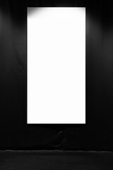 Blank vertical poster hangs on a black wall