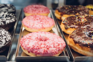 Rich variety of sugar glazed donuts in a showcase.