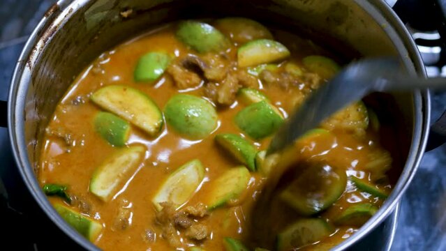 Red curry boiling on a pot with eggpalnt and herb. Making of red curry with chicken, Thai food, Pa neang.