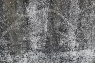 A weathered concrete wall with cracks and peeling paint, showing signs of age and decay.