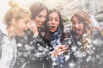 Happy four friends walking on the street and using cellphones
