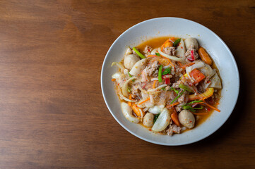 Top view of spicy Seafood Salad on a wooden table, Thai spicy food, Spicy salad, Copy space.